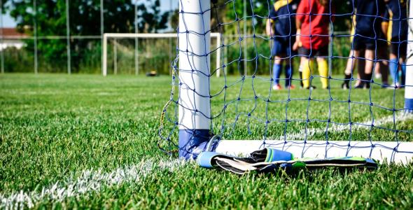 Een goal op een voetbalveld met kinderen erachter
