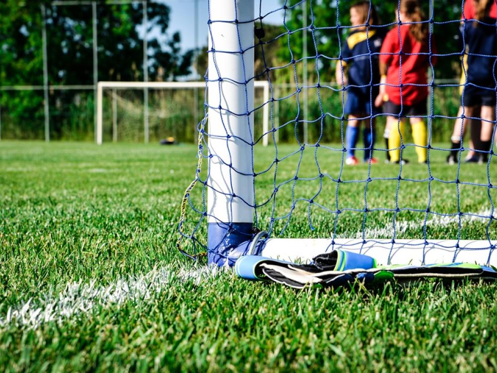 Een goal op een voetbalveld met kinderen erachter